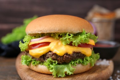 Photo of Tasty cheeseburger with sauce on table, closeup