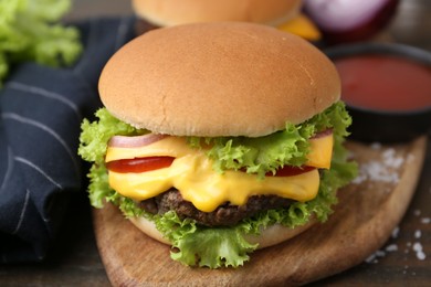 Photo of Tasty cheeseburger with sauce on table, closeup