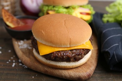Photo of Tasty cheeseburgers served on wooden table, closeup