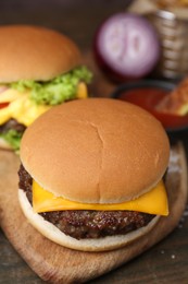 Photo of Tasty cheeseburgers served on wooden table, closeup