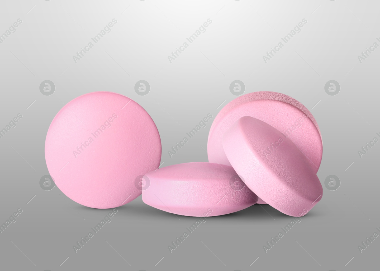 Antibiotic pills. Round pink tablets on grey gradient background Image of Antibiotic pills. Round pink tablets on grey gradient background