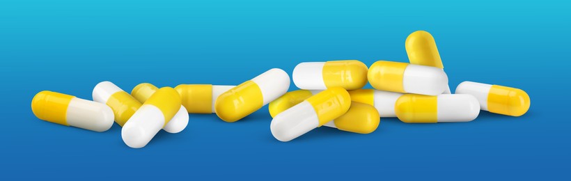 Image of Antibiotic pills. Yellow capsules on blue gradient background. Banner design