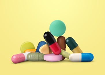 Image of Many different antibiotic pills on yellow background