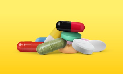 Image of Different antibiotic pills on yellow gradient background. Banner design