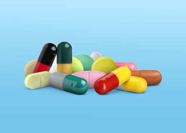 Image of Different antibiotic pills on light blue gradient background