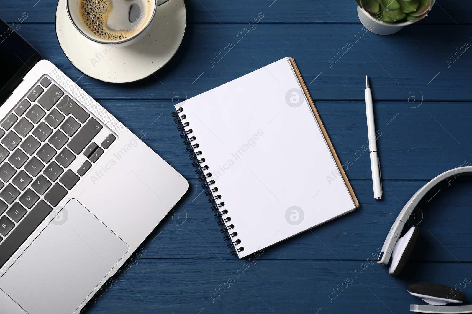 Notebook with pen, laptop, headphones and coffee on blue wooden table, flat lay Photo of Notebook with pen, laptop, headphones and coffee on blue wooden table, flat lay