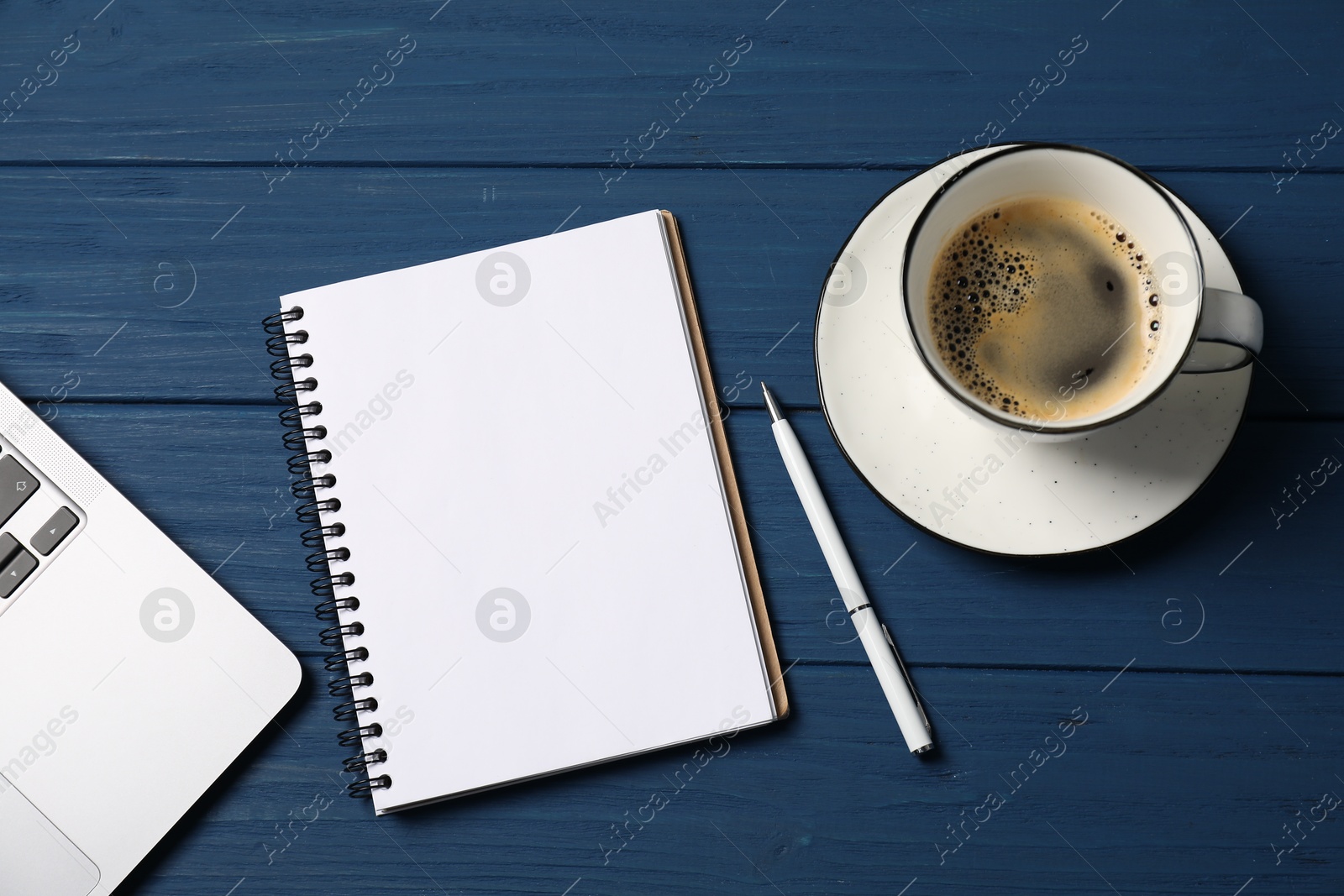 Notebook with pen, laptop and coffee on blue wooden table, flat lay Photo of Notebook with pen, laptop and coffee on blue wooden table, flat lay