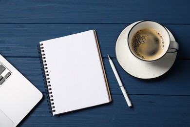 Photo of Notebook with pen, laptop and coffee on blue wooden table, flat lay