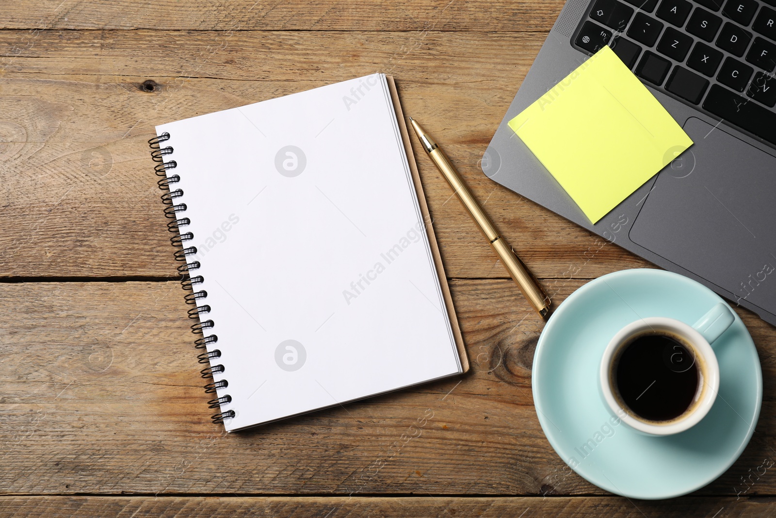 Notebook with pen, sticky note, laptop and coffee on wooden table, flat lay Photo of Notebook with pen, sticky note, laptop and coffee on wooden table, flat lay