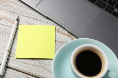 Photo of Sticky note with pen, laptop and coffee on white wooden table, closeup