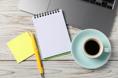 Photo of Notebook with pen, sticky note, laptop and coffee on white wooden table, flat lay