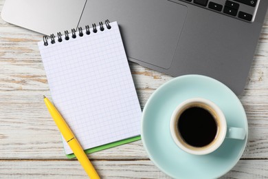 Photo of Notebook with pen, laptop and coffee on white wooden table, flat lay