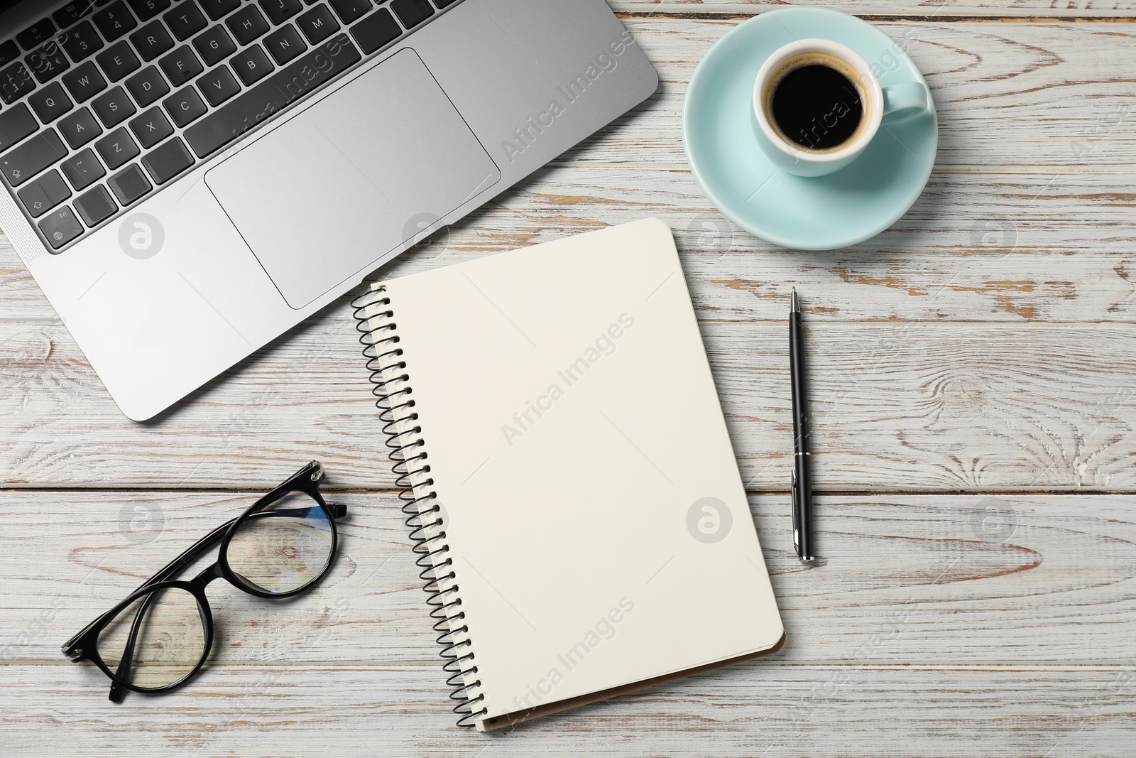 Notebook with pen, laptop, glasses and coffee on white wooden table, flat lay Photo of Notebook with pen, laptop, glasses and coffee on white wooden table, flat lay