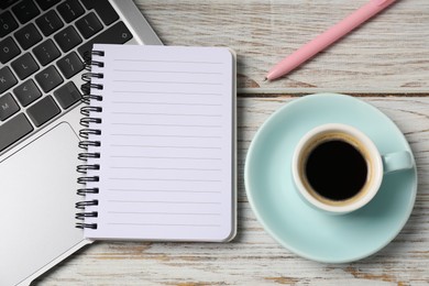 Photo of Notebook with pen, laptop and coffee on white wooden table, top view