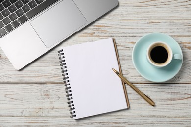 Photo of Notebook with pen, laptop and coffee on white wooden table, top view