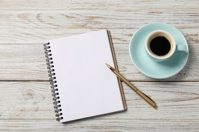 Photo of Notebook with pen and coffee on white wooden table, top view