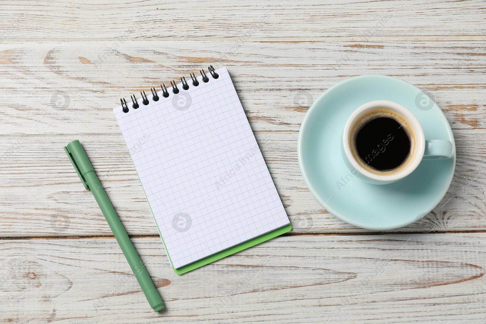 Notebook with pen and coffee on white wooden table, top view Photo of Notebook with pen and coffee on white wooden table, top view