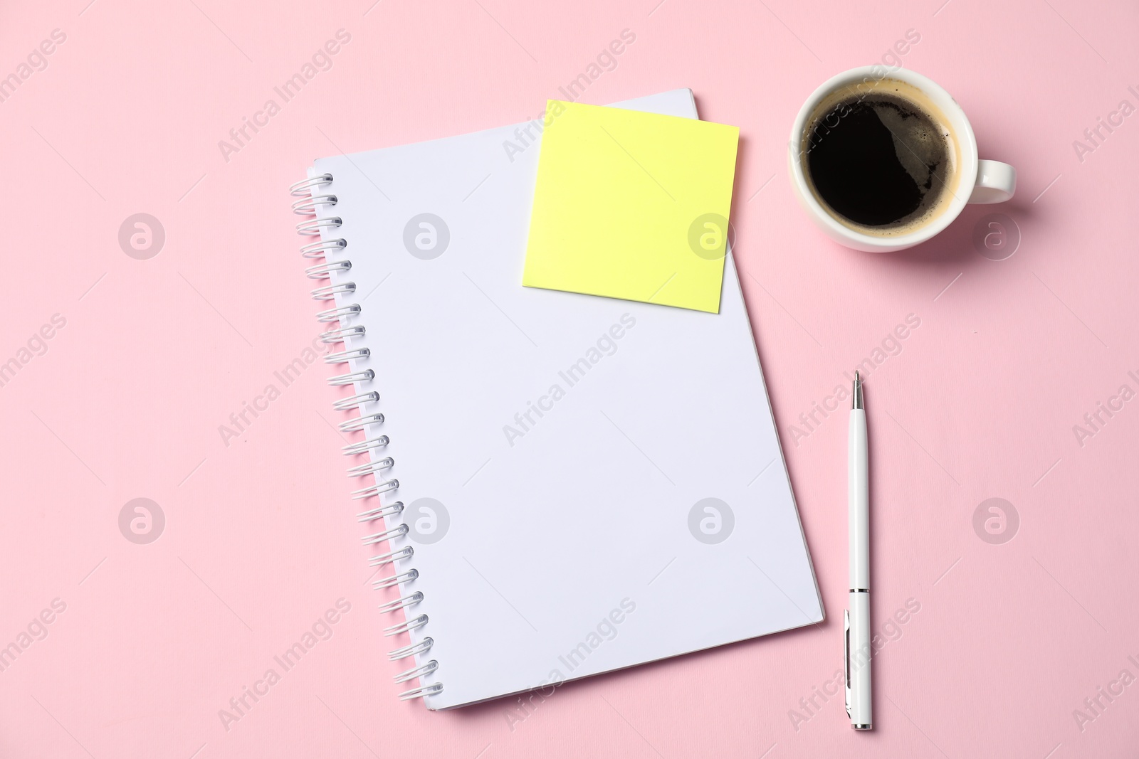 Notebook with sticky note, pen and coffee on pink background, top view Photo of Notebook with sticky note, pen and coffee on pink background, top view