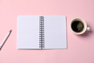 Photo of Notebook with pen and coffee on pink background, top view