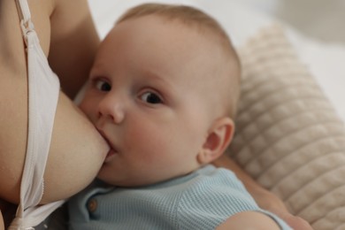 Photo of Mother breastfeeding her little baby indoors, closeup
