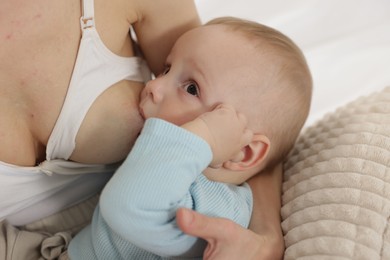 Photo of Mother breastfeeding her little baby indoors, closeup