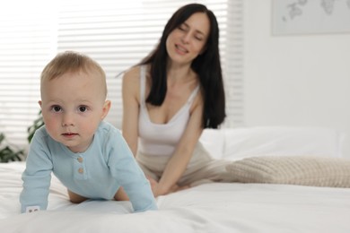 Photo of Mother with her little baby on bed at home, selective focus