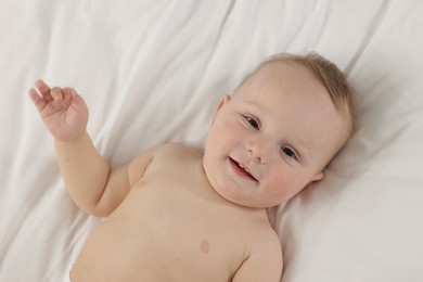 Photo of Cute little baby lying on bed, above view