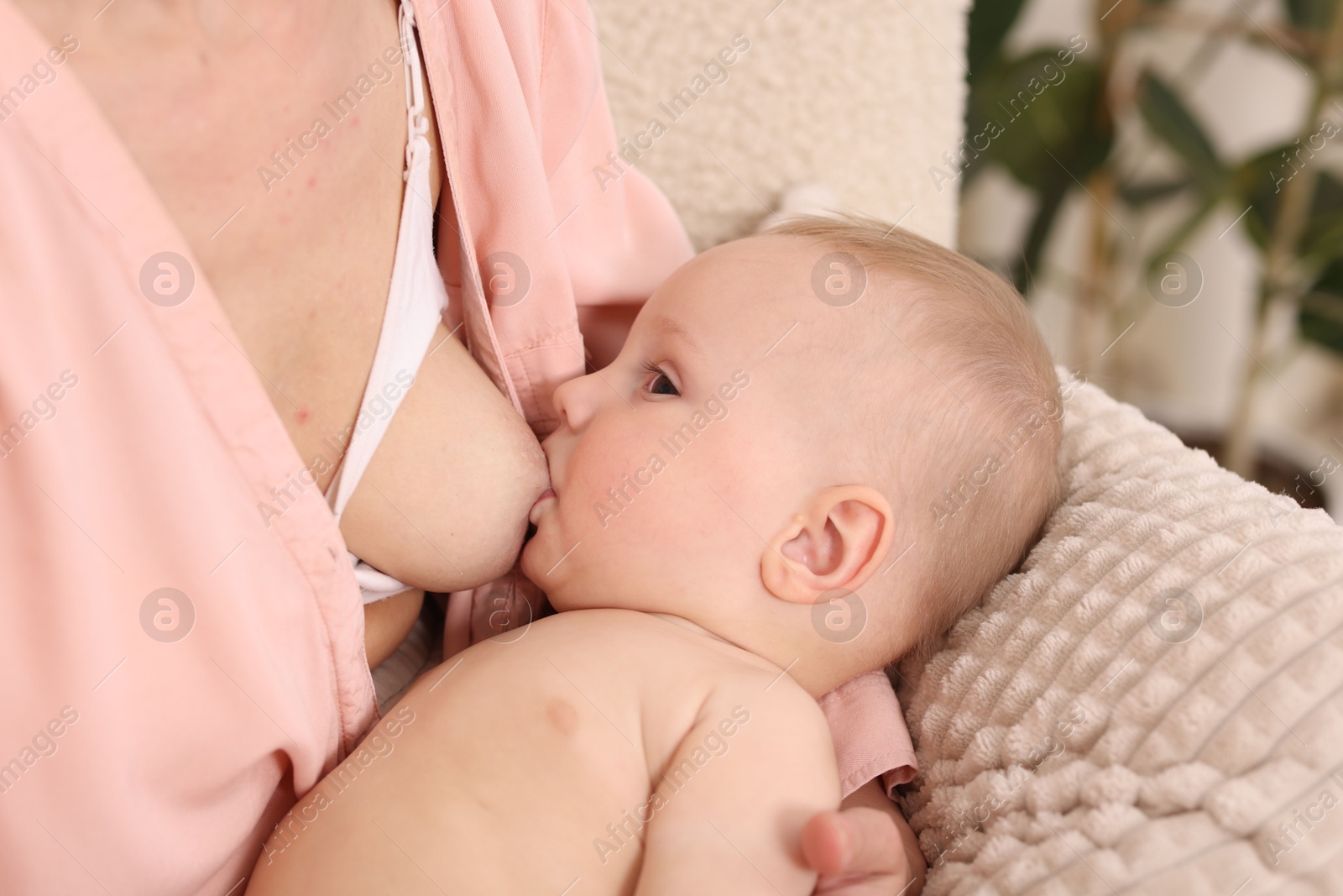 Mother breastfeeding her little baby indoors, closeup Photo of Mother breastfeeding her little baby indoors, closeup