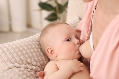 Photo of Mother breastfeeding her little baby indoors, closeup