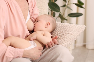 Photo of Mother breastfeeding her little baby indoors, closeup