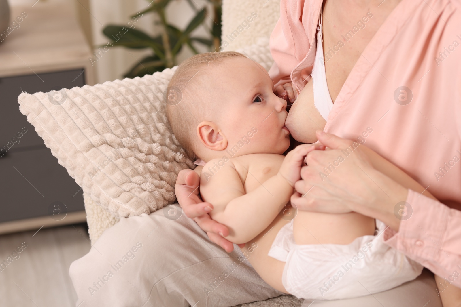 Mother breastfeeding her little baby indoors, closeup Photo of Mother breastfeeding her little baby indoors, closeup