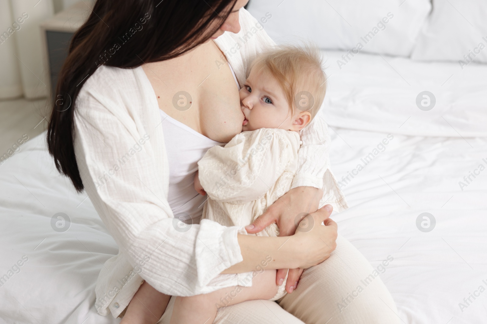 Mother breastfeeding her little baby on bed indoors, closeup Photo of Mother breastfeeding her little baby on bed indoors, closeup