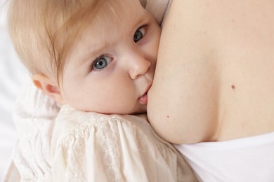 Photo of Mother breastfeeding her cute little baby, closeup
