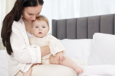 Photo of Mother with her little baby on bed indoors