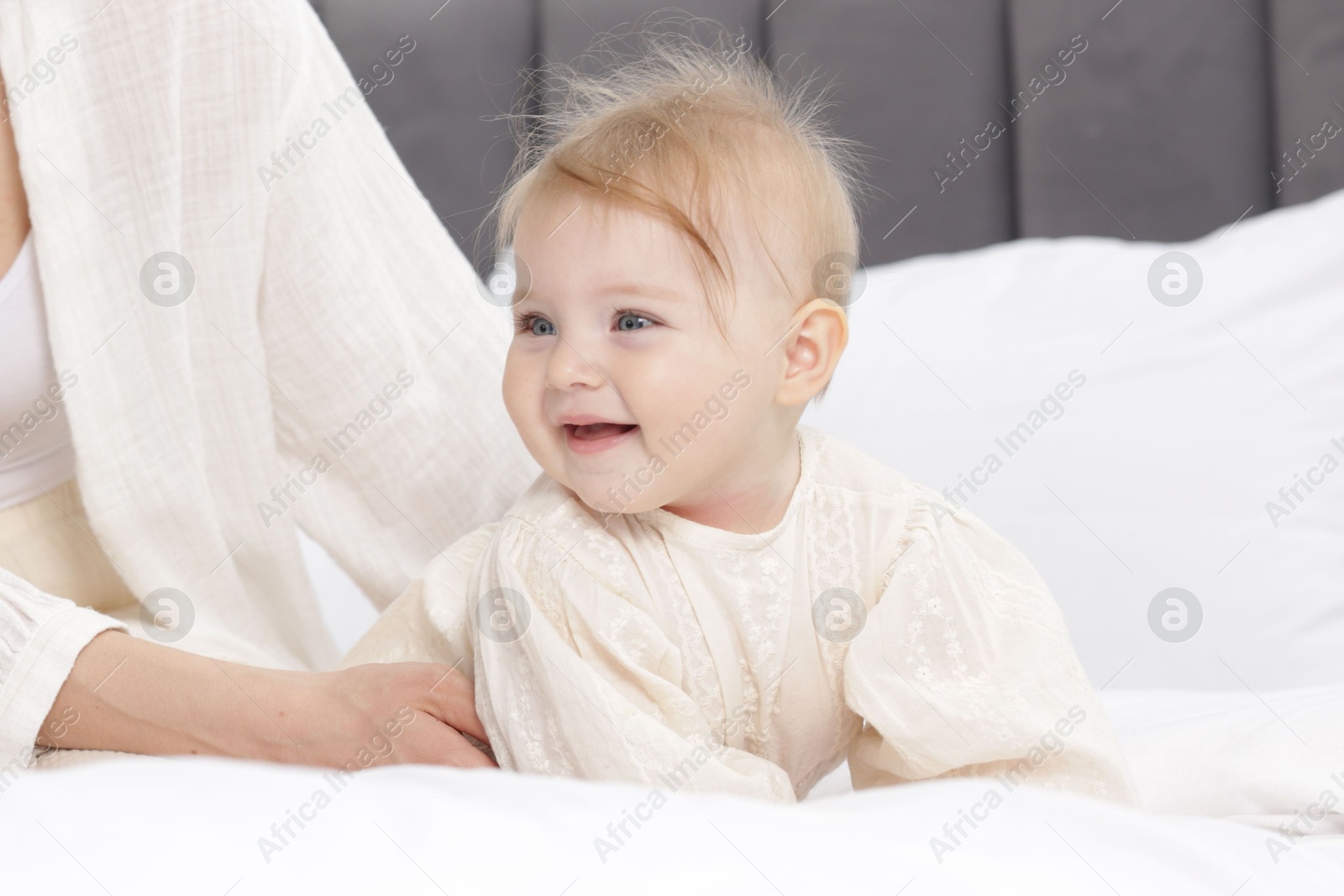 Cute little baby and mother on bed, closeup Photo of Cute little baby and mother on bed, closeup