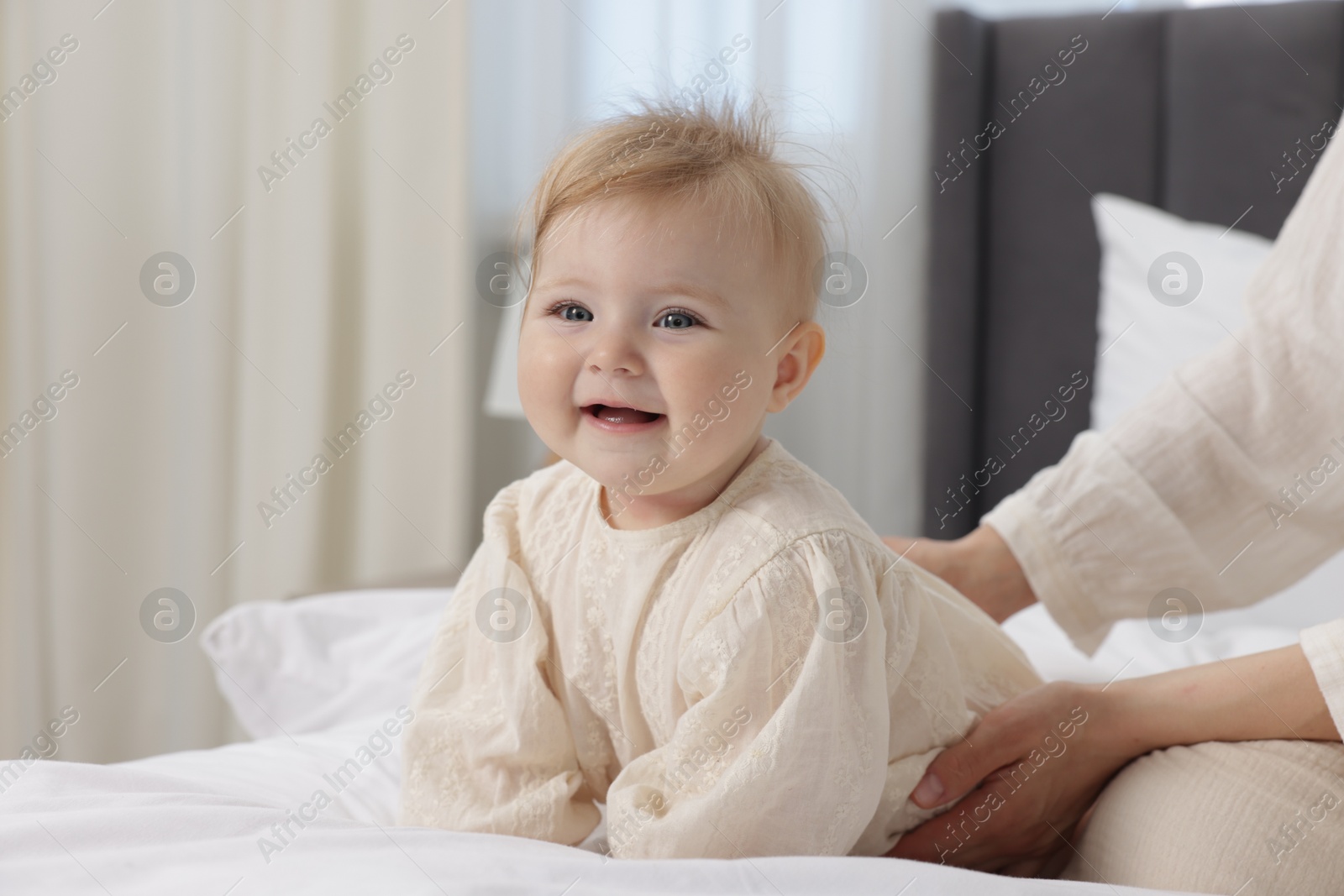 Happy little baby and mother on bed indoors, closeup Photo of Happy little baby and mother on bed indoors, closeup