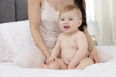 Photo of Mother with her little baby on bed at home, closeup