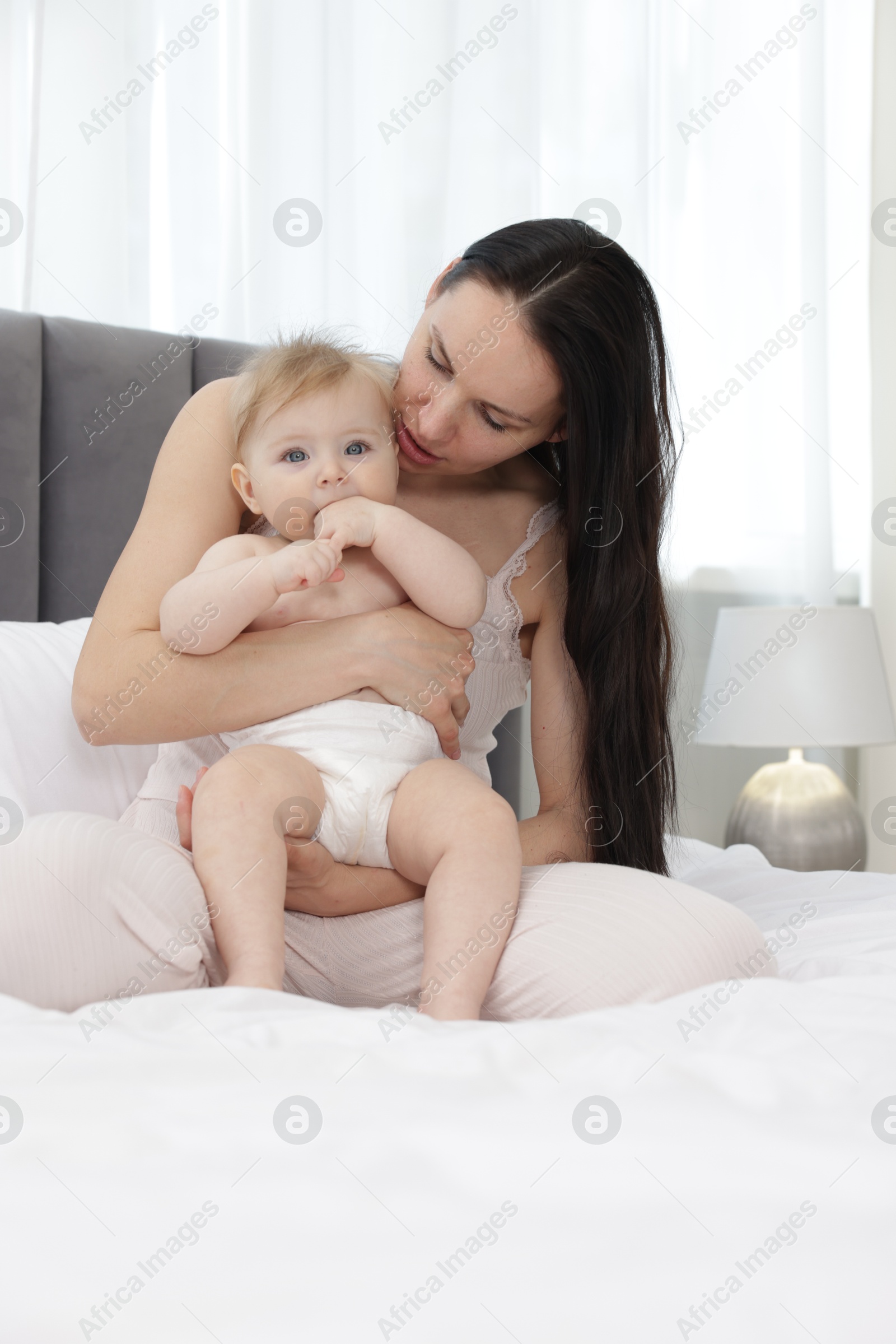 Mother with her little baby on bed at home Photo of Mother with her little baby on bed at home