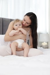 Photo of Mother with her little baby on bed at home