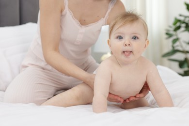 Photo of Cute little baby and mother on bed indoors, closeup