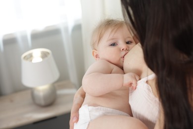 Photo of Mother breastfeeding her cute little baby indoors, closeup. Space for text