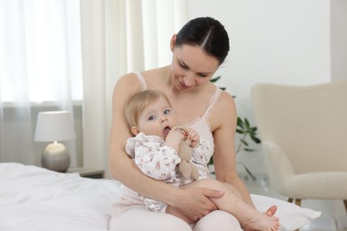 Photo of Mother with her little baby on bed at home