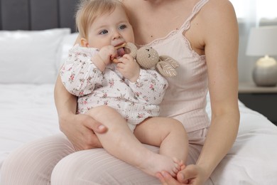 Photo of Mother with her little baby on bed at home, closeup