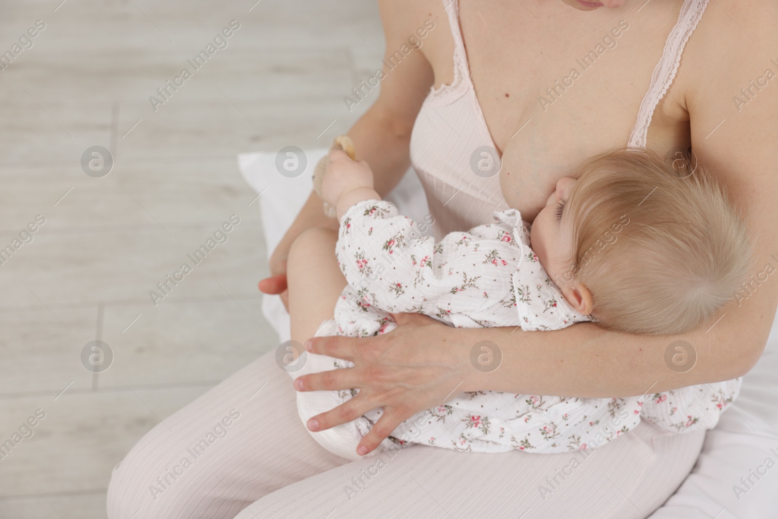 Mother breastfeeding her cute little baby indoors, closeup. Space for text Photo of Mother breastfeeding her cute little baby indoors, closeup. Space for text