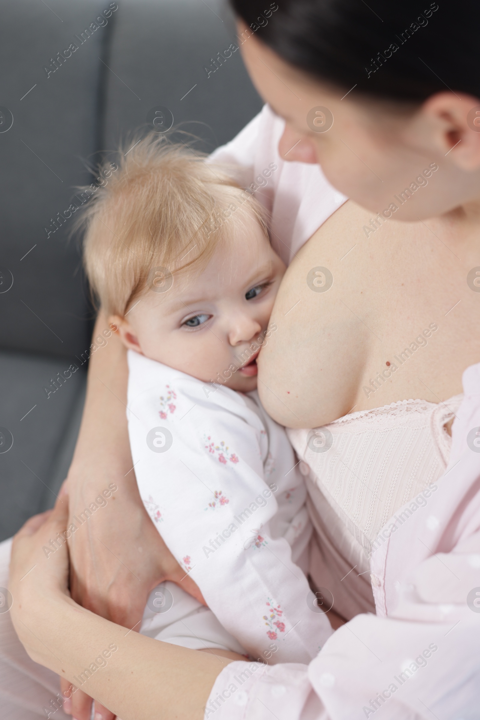 Mother breastfeeding her little baby on sofa Photo of Mother breastfeeding her little baby on sofa