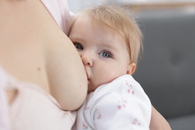 Photo of Mother breastfeeding her cute little baby indoors, closeup