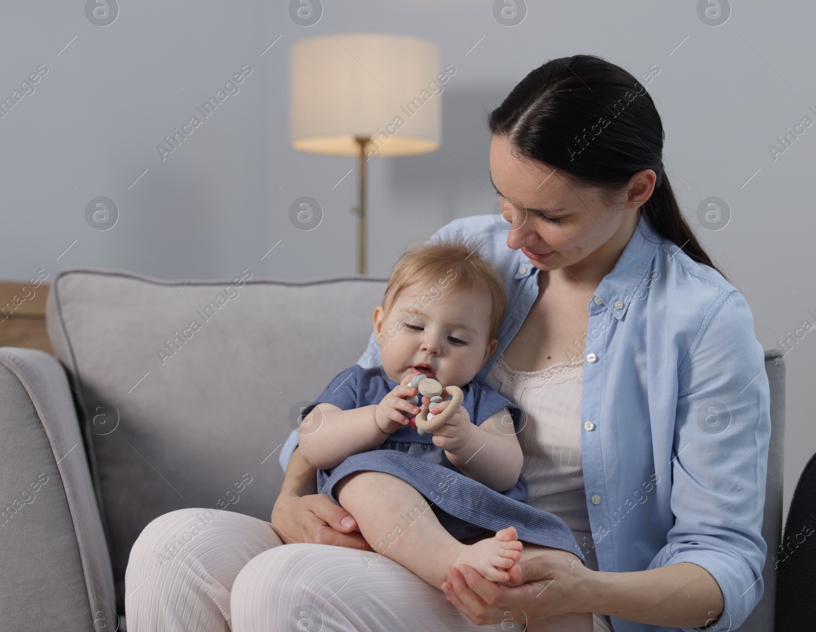 Mother with her little baby on armchair indoors Photo of Mother with her little baby on armchair indoors
