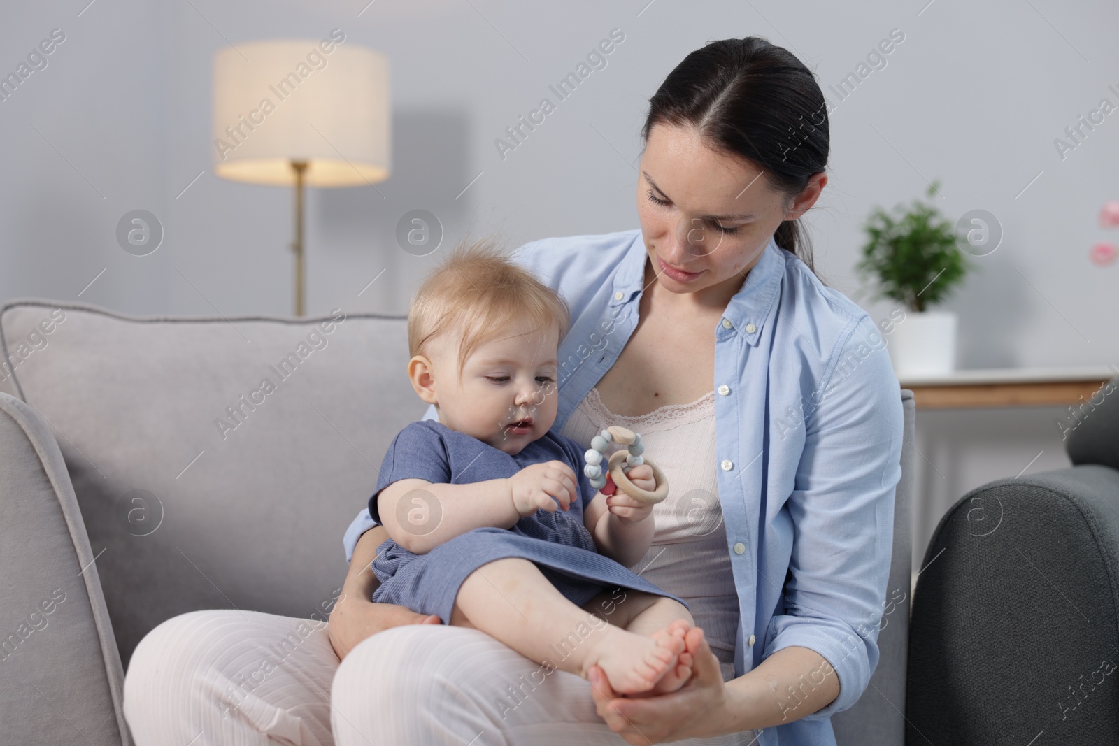 Mother with her little baby on armchair indoors Photo of Mother with her little baby on armchair indoors