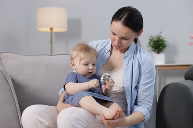 Photo of Mother with her little baby on armchair indoors