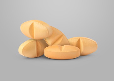 Image of Antibiotic pills. Oval orange tablets on grey background
